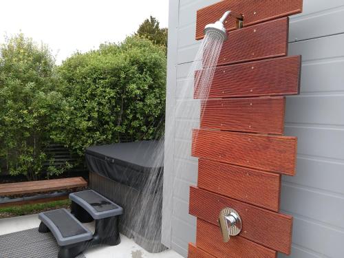 a shower is attached to the side of a house at Tawa Tiny Stays Luxury adults only with spa in Taupo