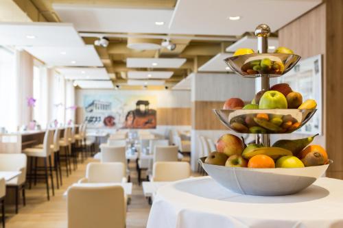 a bowl of fruit on a table in a restaurant at Continental Hotel Lausanne in Lausanne