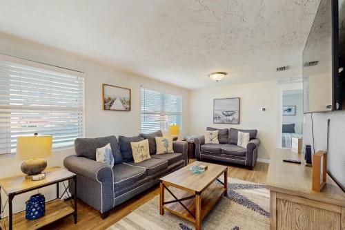 a living room with a couch and a table at Pinellas Park Cottage in St. Petersburg