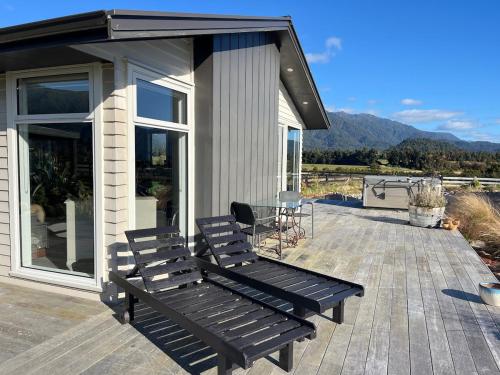 a deck with two benches on a house at Glacier Lake House in Tatare