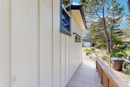a wooden walkway next to a building with a window at Kat'z Place in Neskowin