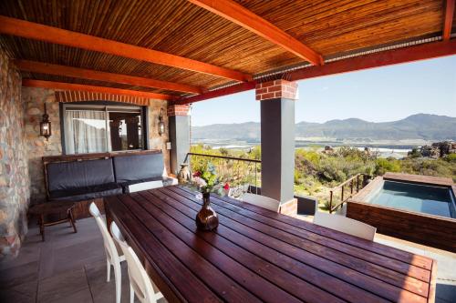 a wooden table and chairs on a deck with a pool at Wolfkop Nature Reserve in Citrusdal