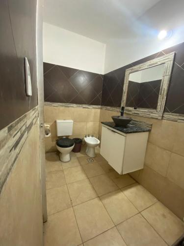a bathroom with two toilets and a sink and a mirror at Kingston House in La Rioja