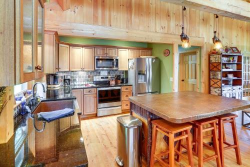 a large kitchen with wooden cabinets and a large island at 4 Mi to Mount Snow West Dover Cabin with Game Room in West Dover