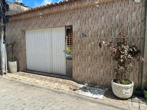 a building with a door and a potted plant at Casa Porto do Amor in Porto De Galinhas