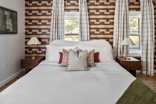 a large white bed in a room with windows at Hudson Valley Hot Tub Sauna Fire Pit Games in Hudson