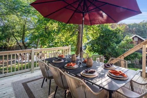 a dining table with an umbrella on a deck at Hudson Valley Hot Tub Sauna Fire Pit Games in Hudson