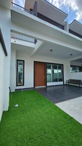 a house with a green lawn in front of it at DHarmony Homestay Port Dickson in Port Dickson