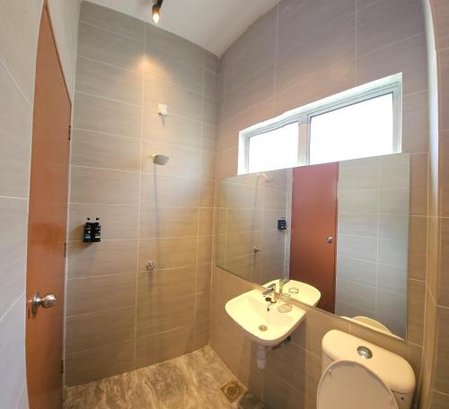 a bathroom with a sink and a toilet and a window at DHarmony Homestay Port Dickson in Port Dickson