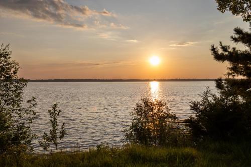 a sunset over a large body of water at Timber Haven Aframe Cabin - Brand New Hot Tub in Friendship