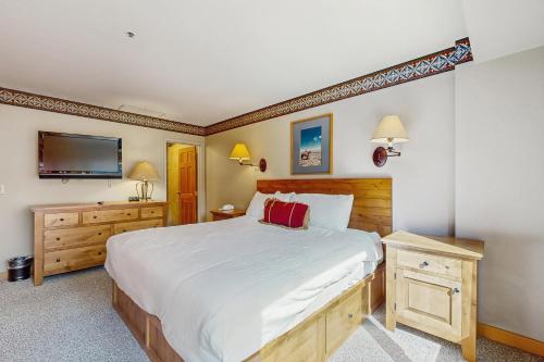 a bedroom with a large bed and a flat screen tv at Shoshone 1919 in Big Sky