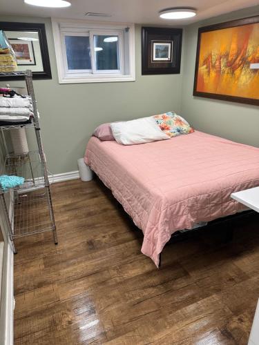 een slaapkamer met een bed en een schilderij aan de muur bij Toronto Upper Beaches Apartment in Toronto