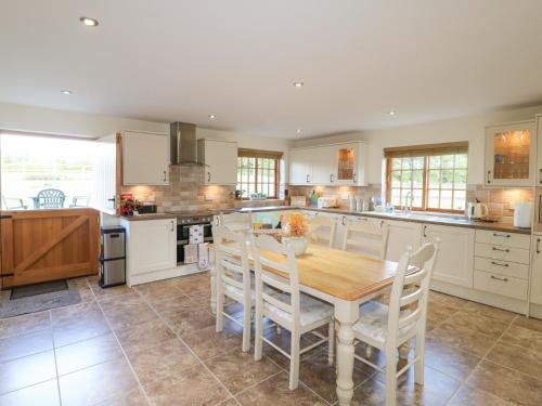 a kitchen with a wooden table and white cabinets at The Dairy in Nottingham