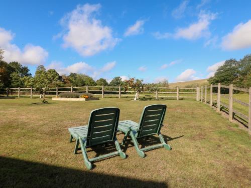 two chairs sitting in the grass next to a fence at The Dairy in Nottingham