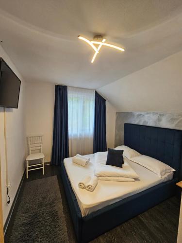 a bedroom with a large bed with a blue headboard at Vibe House Madisson in Braşov