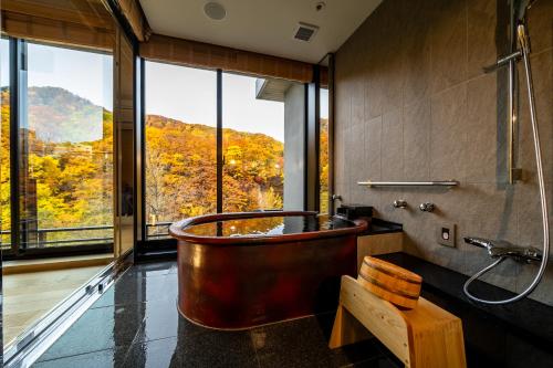 a large tub in a bathroom with a window at Chalet Ivy Jozankei in Jozankei