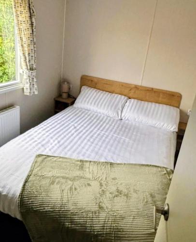 a bedroom with a bed with a wooden head board at Southview caravan park in Winthorpe