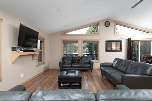 a living room with leather furniture and a flat screen tv at Mama Bear in Valemount