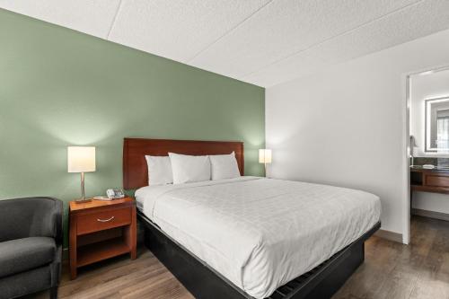 a bed in a room with a chair and a bed sidx sidx sidx at Vagabond Inn Executive Old Town in Sacramento