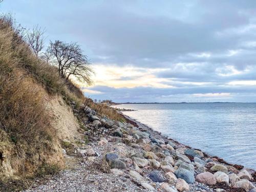 a rocky shoreline with rocks and the water at Seaside Retreat in Kegnaes - By Traum Ferienwohnungen in Østerby