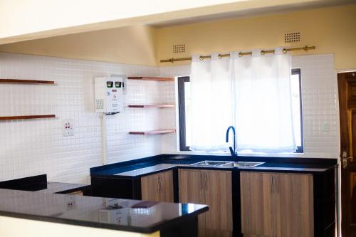 a kitchen with a sink and a window at MTM Apartments in Chilanga