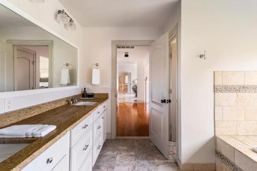 a white bathroom with two sinks and a mirror at Rhinebrook Estate 8 Bed 11 Bath Sleeps 20 in Hyde Park