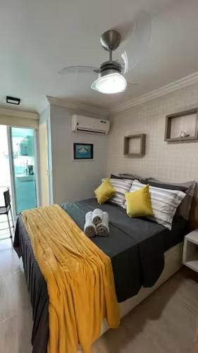 a bedroom with a large bed with yellow and black sheets at Studio Luxuoso in Cabo Frio