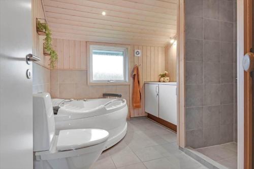 Un baño con bañera blanca y un inodoro. en C11327-Tarm-Sortbaervej-23, en Tarm