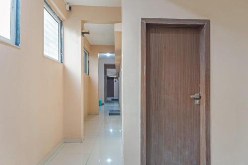 a hallway with a wooden door in a building at Hotel O Swagat Lodging in Khadki