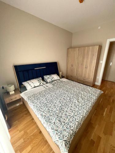 a bedroom with a large bed with a blue headboard at Skopje City Center 1BR Apt - Free Parking & Wi-Fi in Skopje