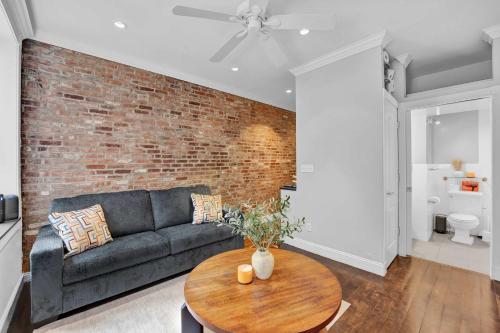 a living room with a couch and a brick wall at Modern 3BR in Gramercy -Near Union Sq NYU in New York