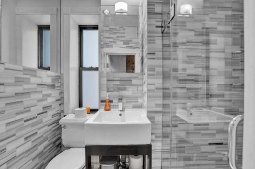 a bathroom with a white sink and a shower at Modern 3BR in Gramercy -Near Union Sq NYU in New York