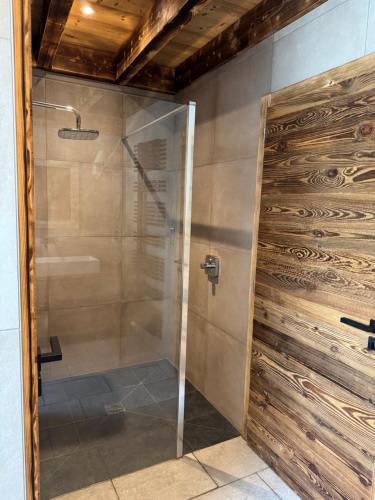 una doccia con porta scorrevole in vetro in bagno di Appartement à la ferme ad Altenbach