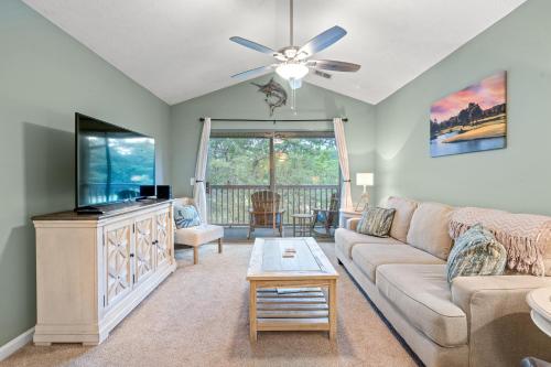 a living room with a couch and a flat screen tv at Charming upgraded 2-bed condo in amazing Pawleys Island True Blue Golf Course in Pawleys Island