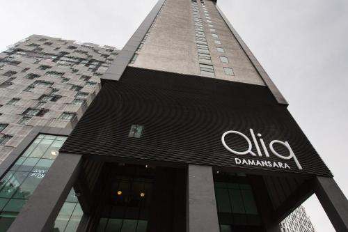 a tall building with a sign on it at Qliq Damansara Hotel in Petaling Jaya