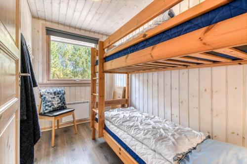 a bedroom with two bunk beds and a chair at C11324-Tarm-Blabaervej-6 in Tarm