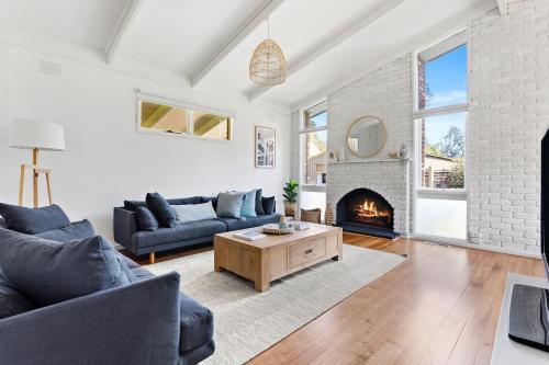a living room with a couch and a fireplace at Bayside Retreat - Cosy Fire Beach Games Room in McCrae