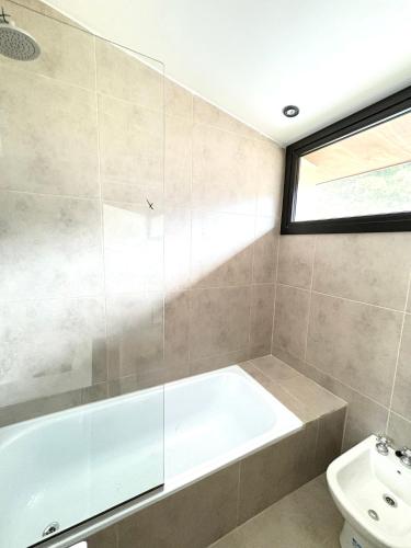 a bathroom with a tub and a toilet at Cantera Tempo 2 in Esquel