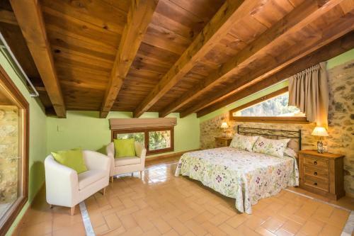 a bedroom with a bed and a chair in a room at Mas De Rogelio in Beceite