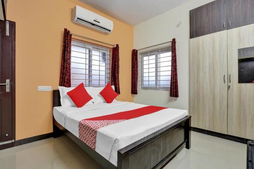 a bedroom with a large bed with red pillows at Hotel O Kb Residency in Gūduvāncheri
