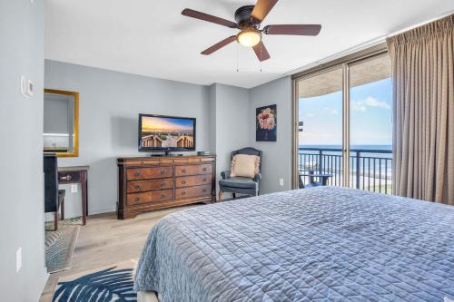 a bedroom with a bed with a ceiling fan and a television at OCEAN VIEW PARADISE Top LOCATION & RESORT with Pool in Myrtle Beach