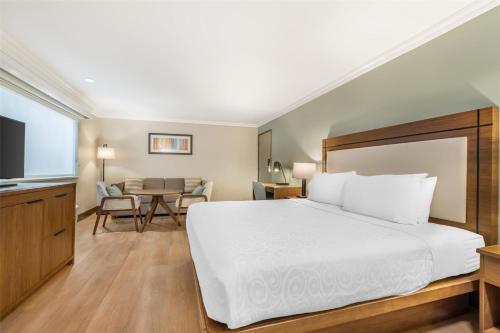 a bedroom with a large bed and a table at Best Western PLUS Burnaby Hotel in Burnaby