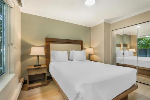 a bedroom with a large white bed and a window at Best Western PLUS Burnaby Hotel in Burnaby