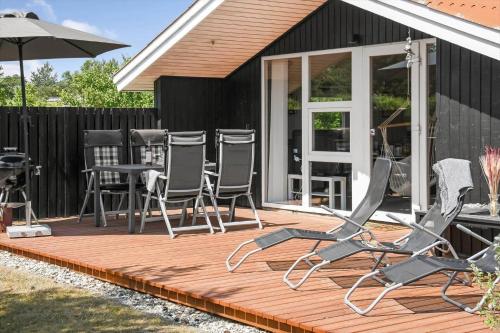 a deck with chairs and an umbrella on a house at C11216-Hemmet-Ildervej-5 in Hemmet