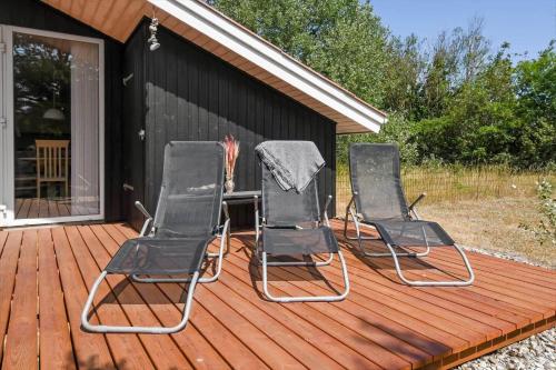 three chairs sitting on a deck on a house at C11216-Hemmet-Ildervej-5 in Hemmet