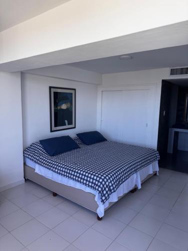a bedroom with a bed in a white room at Apartamento frente al mar in Porlamar