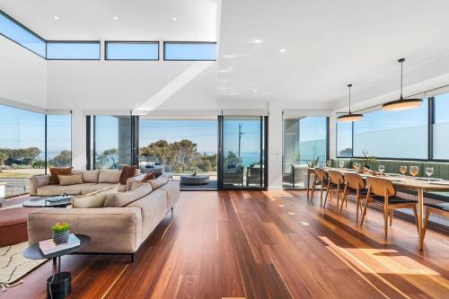 a living room with a couch and a table at Beachfront Luxury - Panoramic Views Games Wineries in Safety Beach