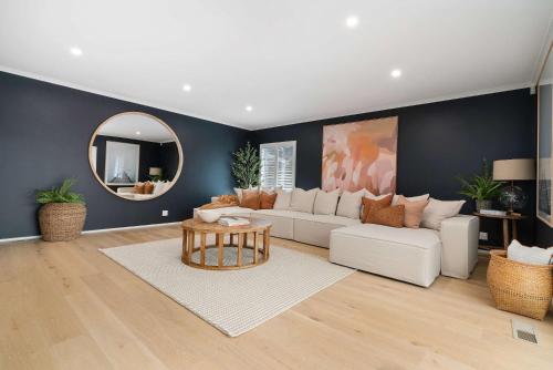 a living room with a white couch and a mirror at Luxury Retreat - Spa Beach Golf Wineries in Mornington