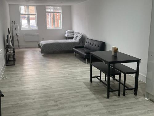 a living room with a table and a couch at Modern Studio Near Heathrow, Tube and Hounslow High Street in Hounslow