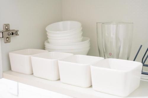 a shelf with white bowls and stacks of plates at 스타폴스테이 in Seoul